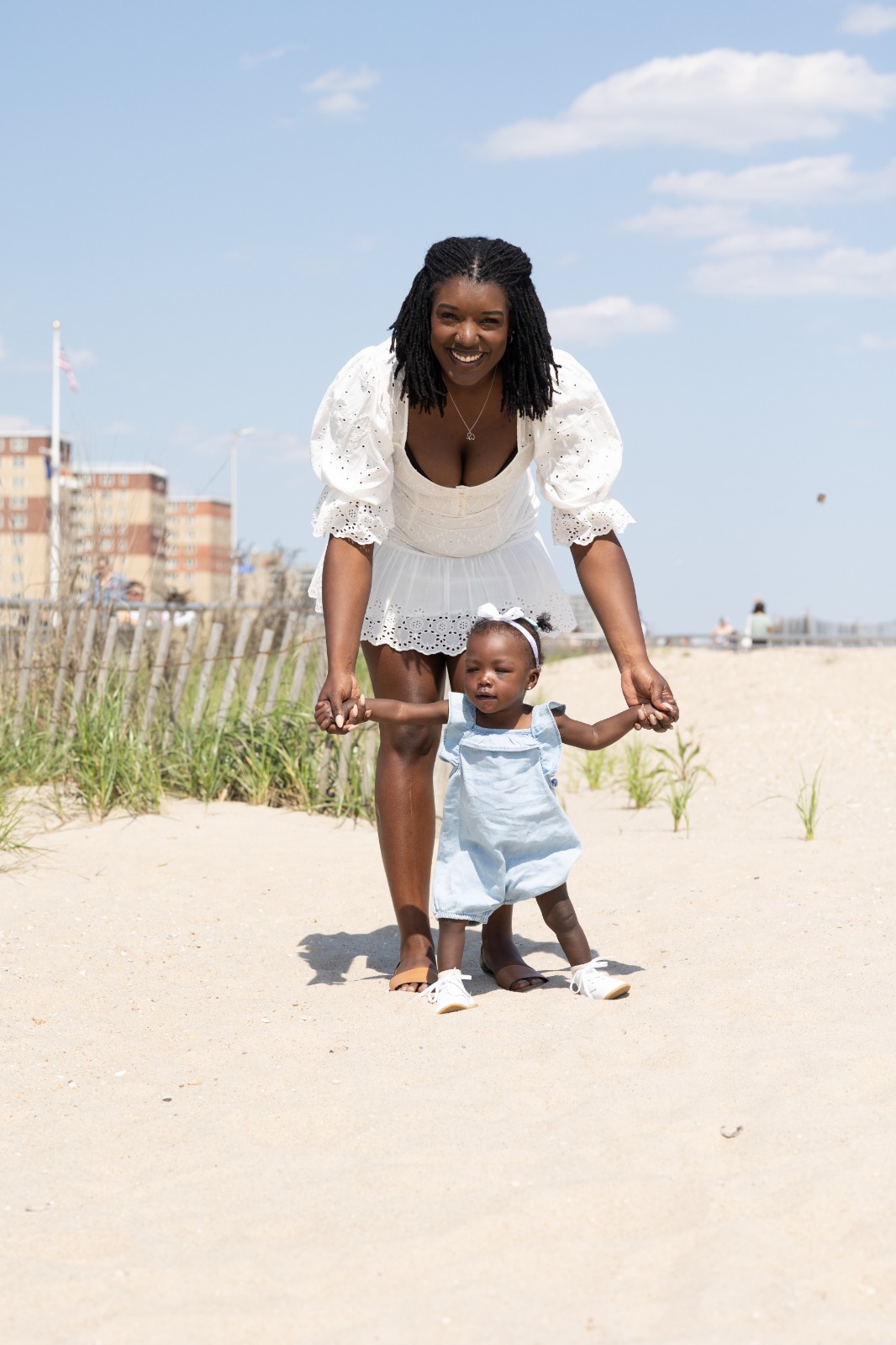 Mom helping baby Renee walk on the beach